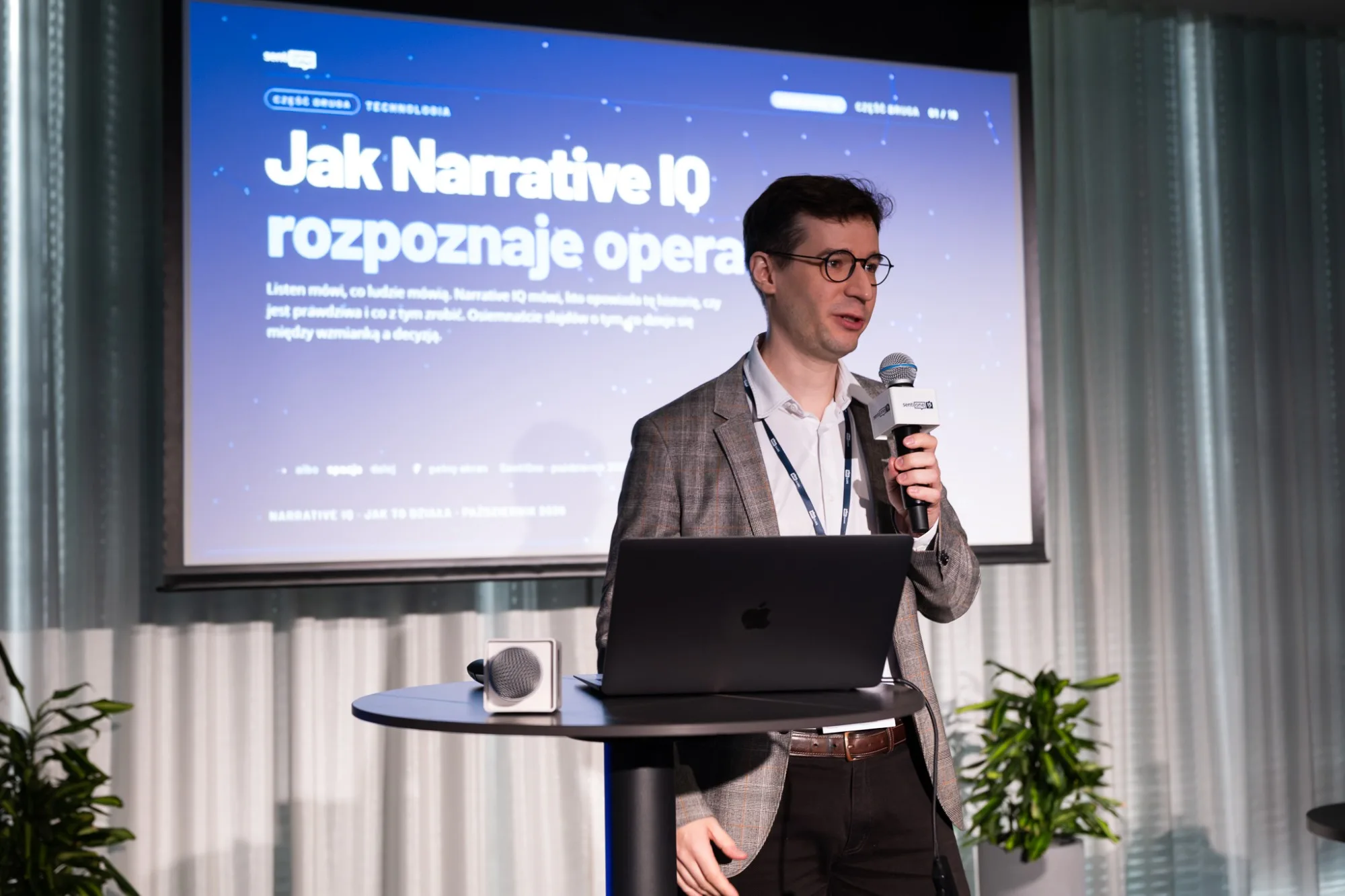Prelegent przedstawia prezentację „Jak Narrative IQ rozpoznaje operacje”
