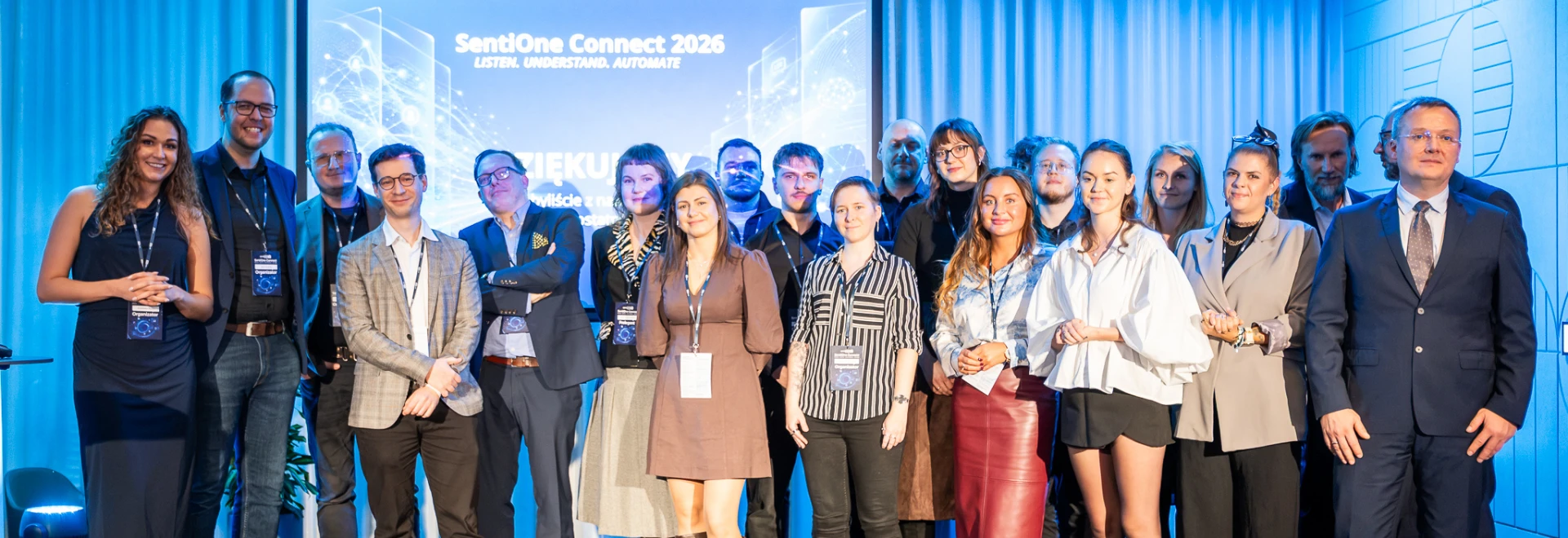 Wspólne zdjęcie prelegentów, panelistów i organizatorów SentiOne Connect 2026 na scenie w Q22